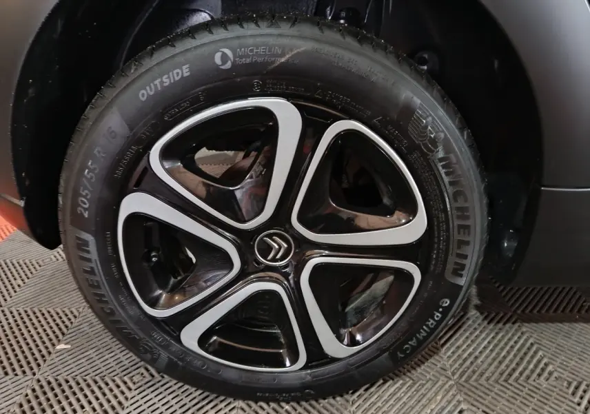Gros plan sur la roue avant droite gris clair de la Citroën C3 BlueHDi 100 BVM PLUS avec jante noire et argentée.