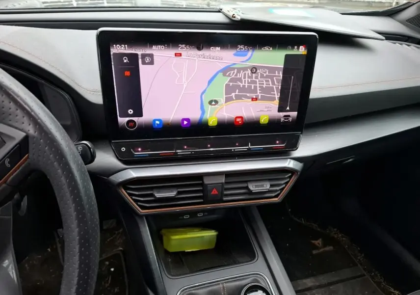 Vue intérieure du tableau de bord du CUPRA Formentor noir, mettant en valeur l'écran tactile central avec navigation et les finitions cuivrées.