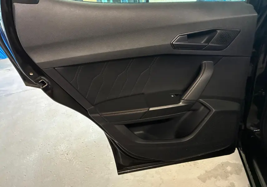 Vue rapprochée de la porte arrière gauche noire du CUPRA Formentor 2.0 TDI avec surpiqûres cuivrées et poignée intégrée.