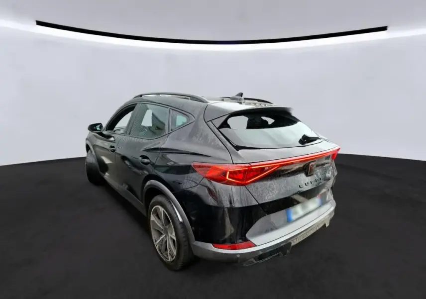 Vue 3/4 arrière droite d'un CUPRA Formentor noir 2022 avec signature lumineuse arrière en bandeau LED rouge.