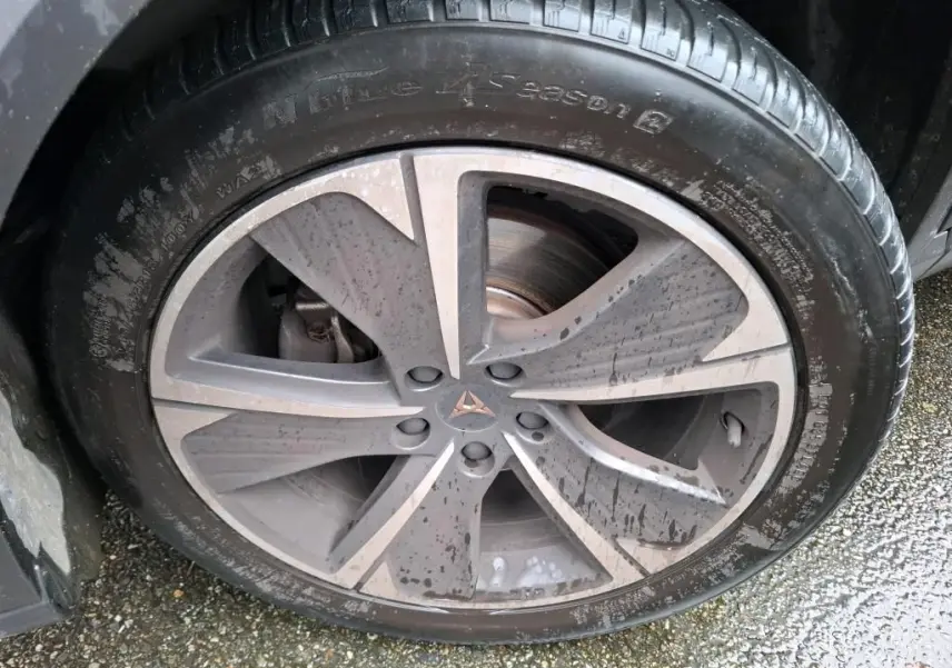 Gros plan sur la jante alu grise à cinq branches du côté gauche d'une CUPRA Formentor noire avec logo central cuivré.