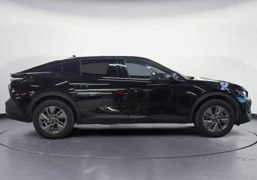 Peugeot 408 PHEV noir vue de profil côté gauche, avec jantes alliage 17 pouces et lignes dynamiques marquées.