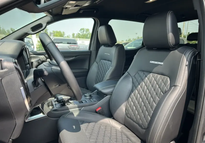 Vue intérieure côté conducteur du Ford Ranger 3.0 V6 Platinum avec sièges cuir noirs matelassés et logo Platinum brodé.