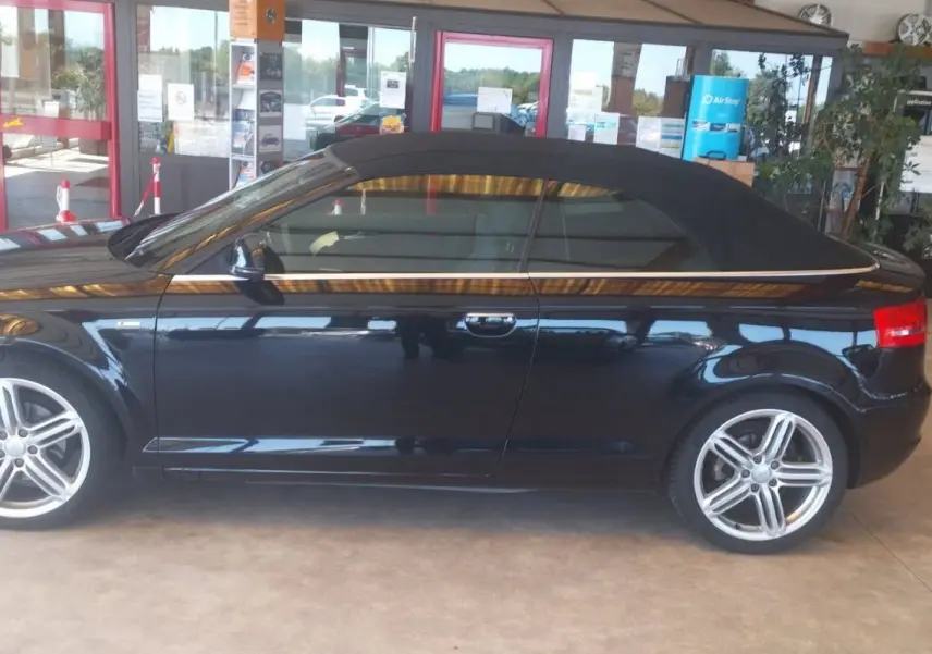 Audi A3 Cabriolet noir vue de profil côté gauche, capote fermée et jantes alliage cinq branches visibles.