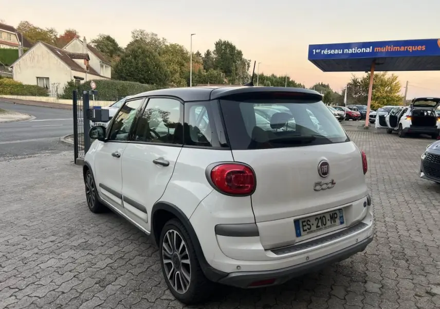 Vue 3/4 arrière droite d'une Fiat 500L Lounge 2017 bi-color avec toit noir, stationnée sur un parking extérieur.