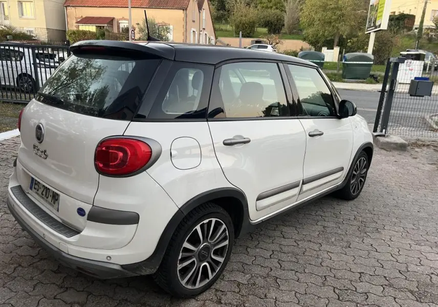 Fiat 500L 2017 vue 3/4 arrière côté droit, peinture bi-color blanc avec toit noir et feux arrière arrondis rouges.