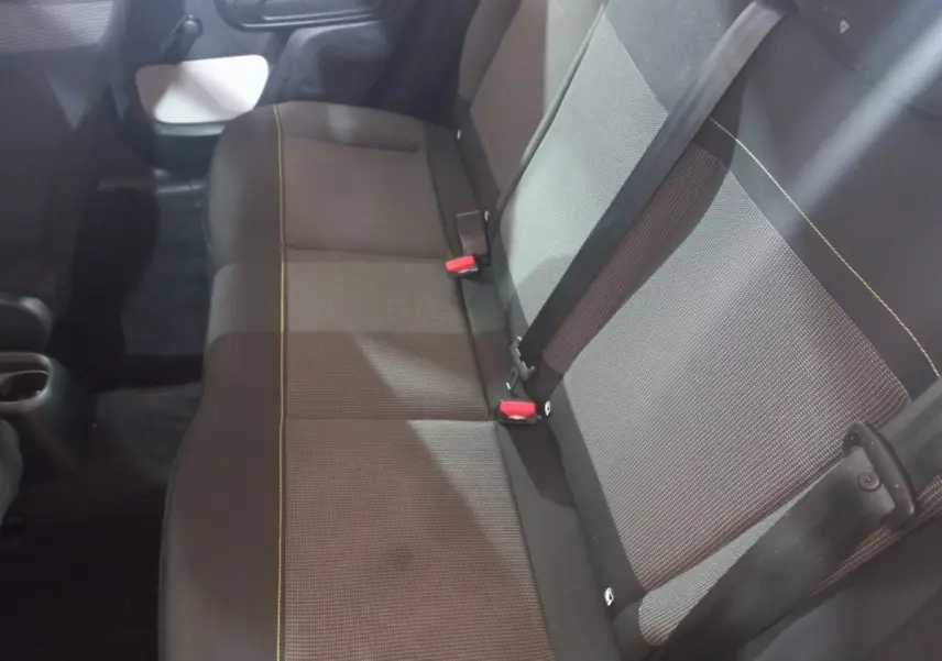 Vue intérieure sur la banquette arrière de la Citroën C3 2024, tissu gris avec ceinture de sécurité noire et boucle rouge.