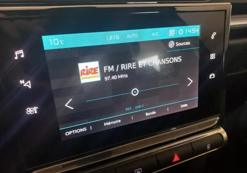 Écran tactile central de la Citroën C3 2024 affichant la radio FM sur fond noir, vue rapprochée intérieure.