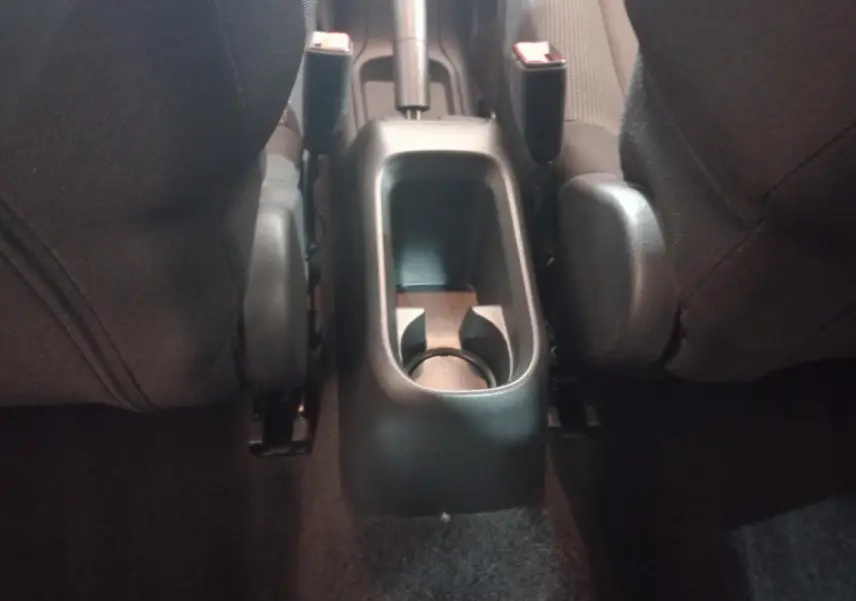 Vue rapprochée de la console centrale arrière entre les sièges noirs d'une Citroën C3 2024.