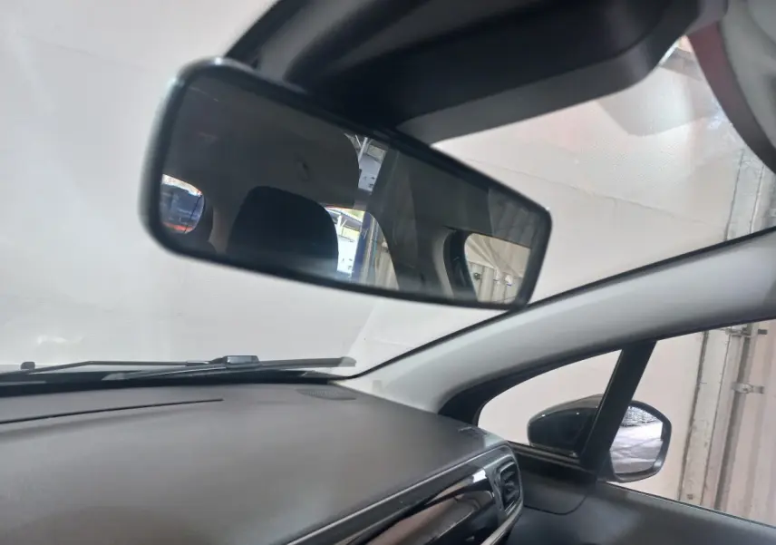 Vue intérieure du tableau de bord et rétroviseur central d'une Citroën C3 noire, avec rétroviseur extérieur droit visible.