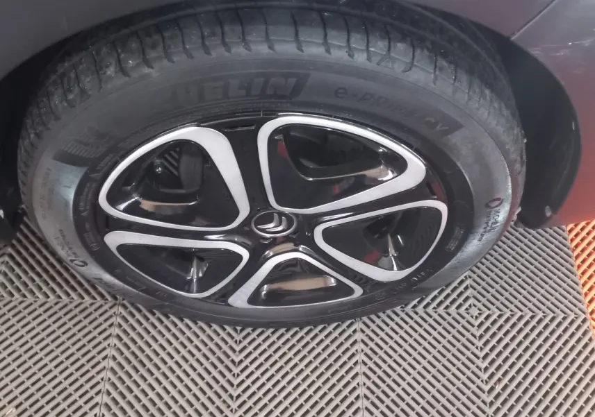 Gros plan sur la roue avant droite noire d'une Citroën C3 2024 avec jante alliage au design moderne.