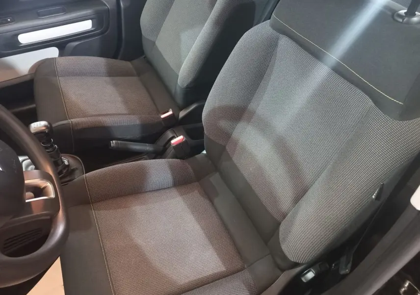 Vue intérieure rapprochée des sièges avant gris foncé et de la boîte manuelle d'une Citroën C3 noire 2024.