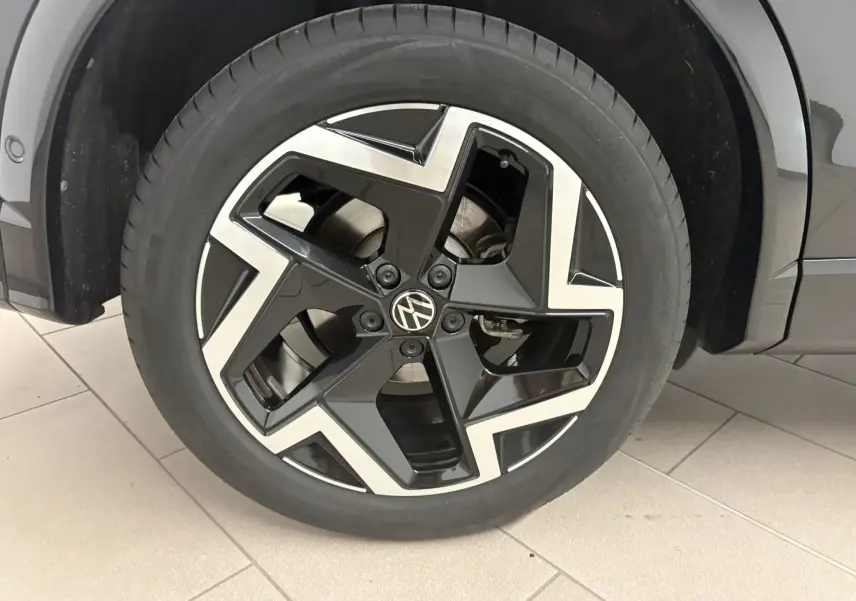 Gros plan sur la jante en alliage noir et argent du Volkswagen Tiguan 2025 Noir Intense Nacré, version R-Line.