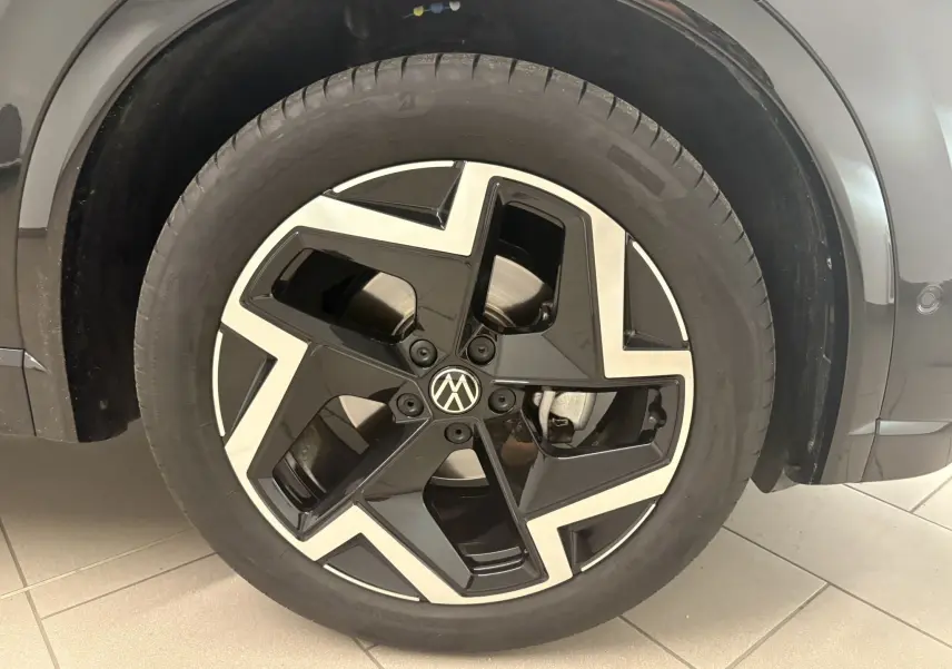 Gros plan sur la roue avant droite du Volkswagen Tiguan 2025 noir intense nacré avec jante alliage R-Line distinctive.