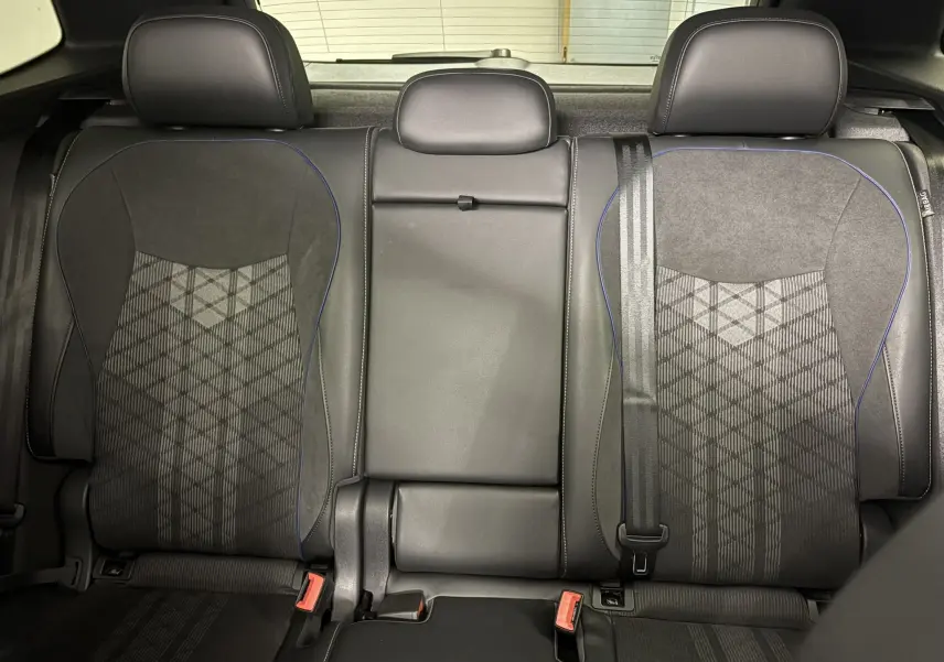 Vue intérieure des sièges arrière en tissu et cuir noir avec surpiqûres bleues du Volkswagen Tiguan 2025 R-Line Edition.