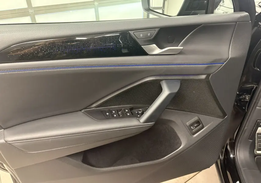 Détail de la porte avant gauche du Volkswagen Tiguan 2025 noir nacré avec commandes électriques et finition R-Line.
