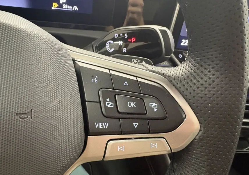 Gros plan sur les commandes multifonctions à droite du volant perforé du Volkswagen Tiguan 2025, intérieur noir.