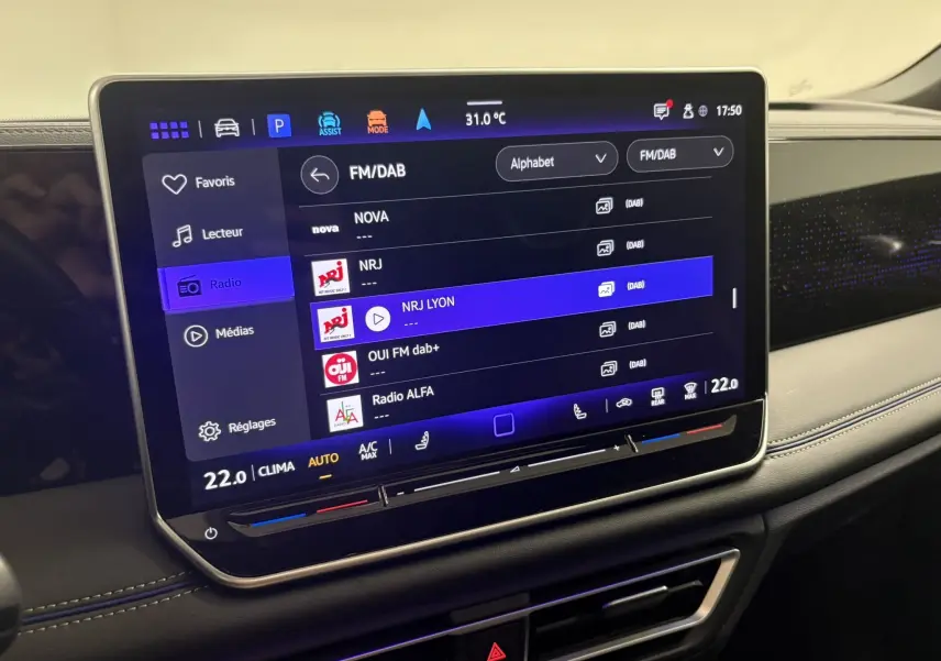 Écran tactile central du Volkswagen Tiguan 2025 affichant les options radio, avec tableau de bord noir et finitions modernes.