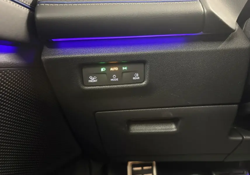 Détail du panneau de commandes d’éclairage avec éclairage d’ambiance bleu dans l’habitacle du Volkswagen Tiguan noir intense nacré.