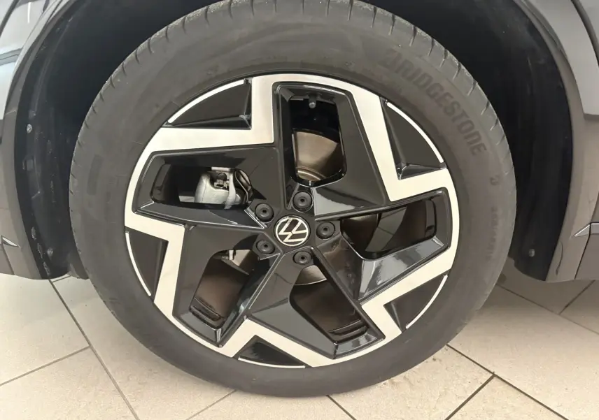 Gros plan sur la jante noire et argentée du Volkswagen Tiguan 2025, version R-Line avec peinture Noir Intense Nacré.