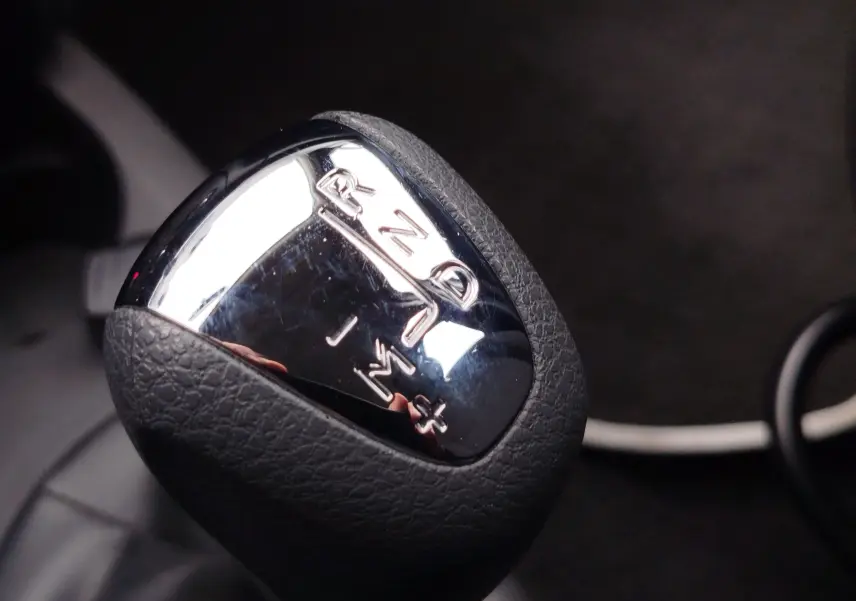 Gros plan sur le levier de vitesses automatique chromé et noir de la Dacia Sandero blanc glacier 2019.