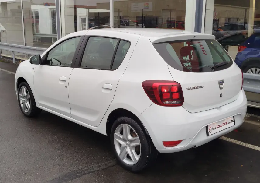 Vue 3/4 arrière droite d'une Dacia Sandero blanc glacier de 2019 avec feux arrière LED et cinq portes.