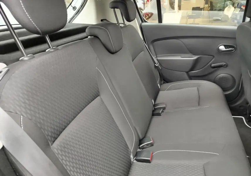 Vue latérale intérieure du siège arrière en tissu gris foncé de la Dacia Sandero Lauréate 2019, avec appuie-têtes et ceintures visibles.
