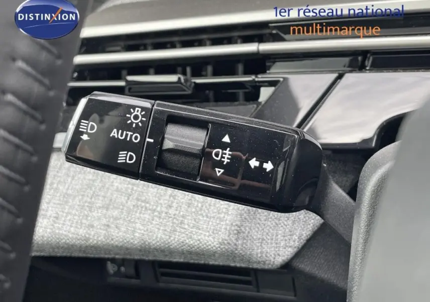 Gros plan sur la commande des feux et clignotants à gauche du volant du Peugeot 3008 noir, intérieur moderne.