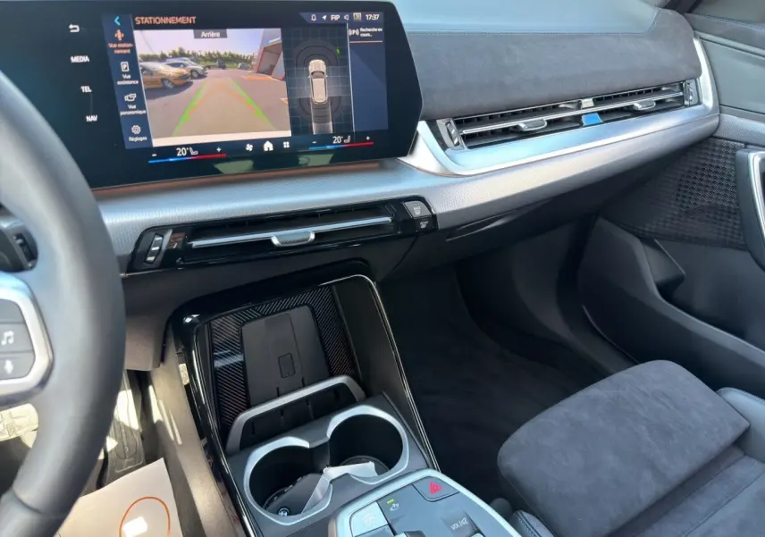 Vue intérieure côté passager du tableau de bord et console centrale noire avec écran tactile du BMW X1 blanc 2025 M SPORT.