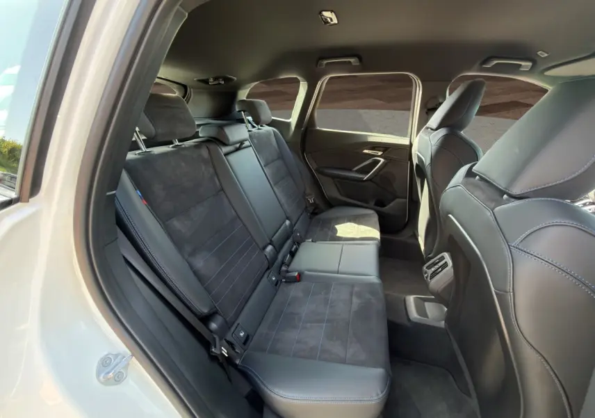 Vue intérieure côté droit montrant les sièges arrière en cuir et alcantara noirs du BMW X1 blanc 2025 M SPORT.