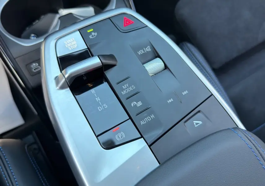 Gros plan sur la console centrale noire et argentée du BMW X1 sDrive20d 2025 avec levier de vitesses et commandes tactiles.