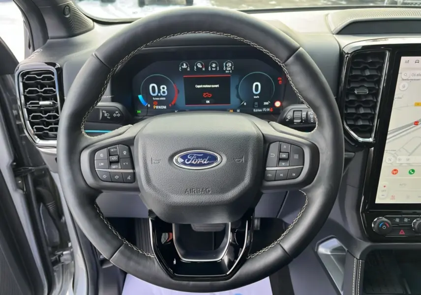 Vue intérieure centrée sur le volant cuir noir avec commandes multifonctions du Ford Ranger gris iconic 2026.