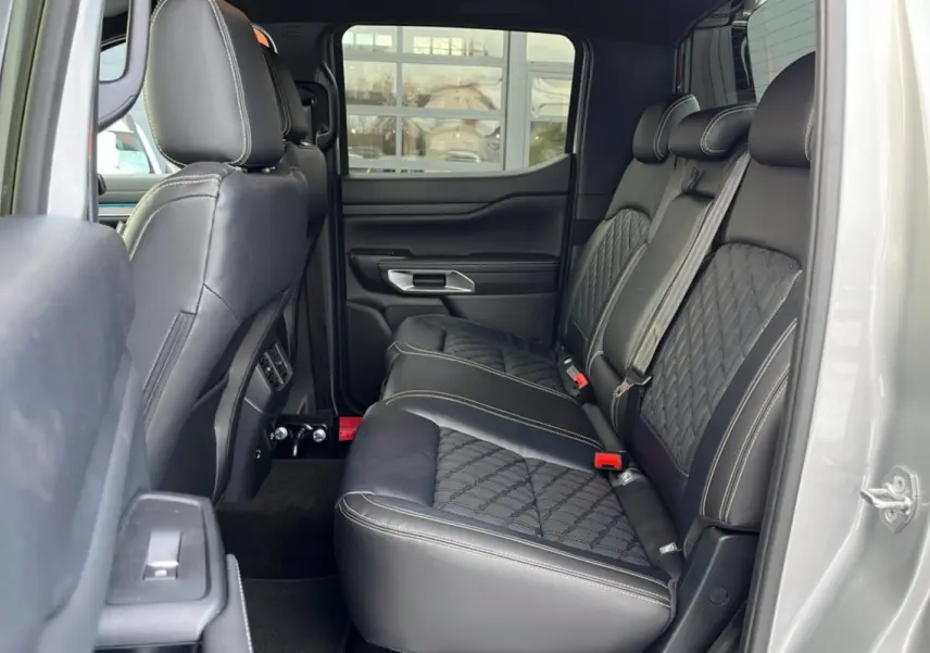 Vue latérale intérieure des sièges arrière en cuir noir avec surpiqûres blanches du Ford Ranger gris iconic 2026.