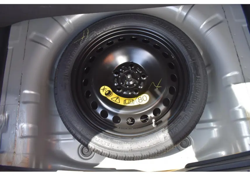 Gros plan sur la roue de secours galette 16 pouces dans le coffre d'une Ford Focus SW 2025 Moondust Silver.