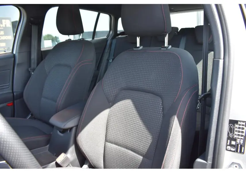 Vue intérieure côté avant droit montrant les sièges tissu noir avec surpiqûres rouges du Ford Focus SW 2025 Moondust Silver.