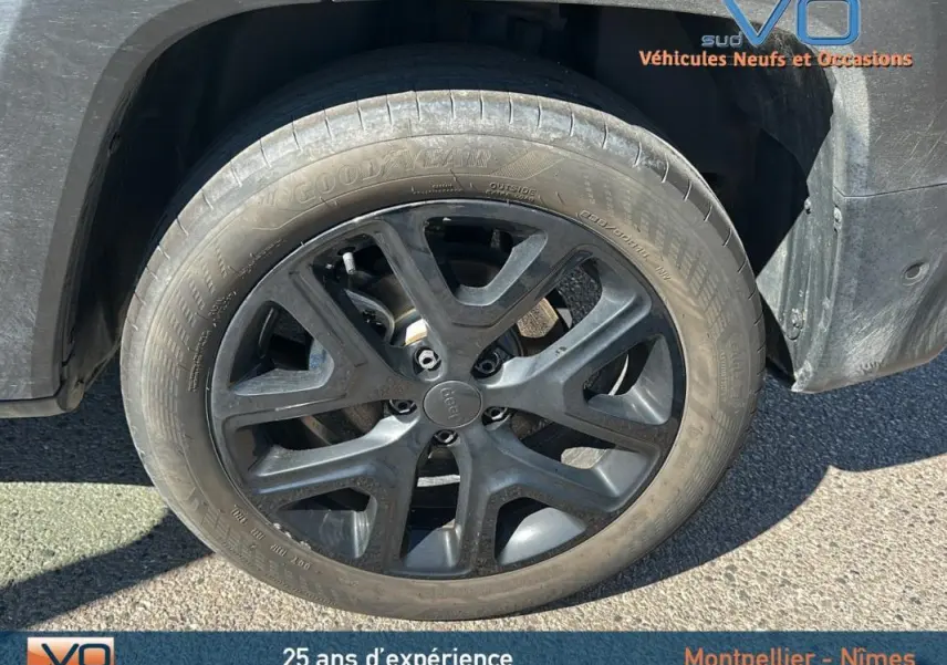 Gros plan sur la jante alliage noire de 18 pouces du côté gauche d'un Jeep Renegade noir 2024.