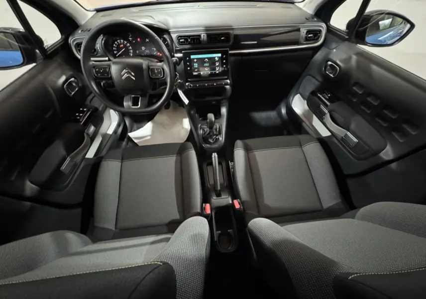 Vue intérieure avant de la Citroën C3 2018, tableau de bord noir avec écran tactile et sièges tissu gris.