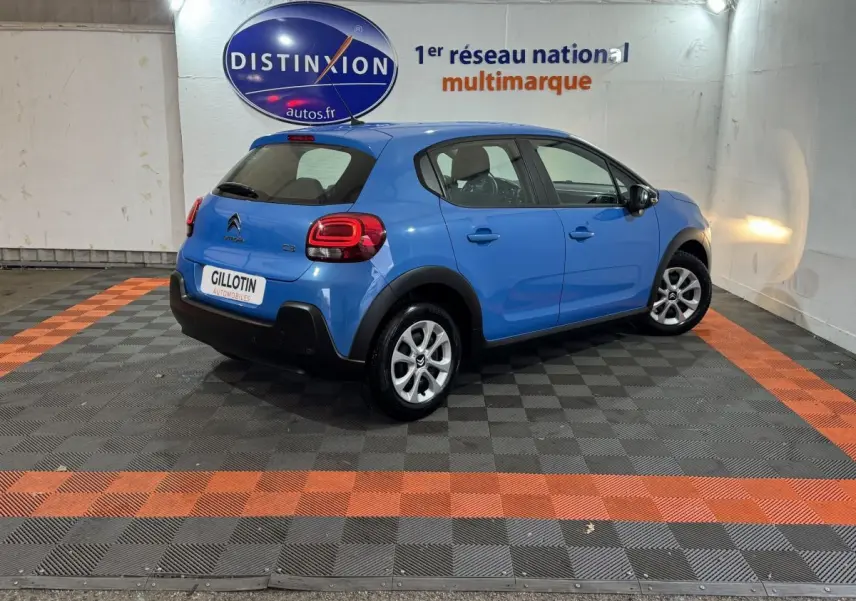 Citroën C3 bleu vue 3/4 arrière droit dans un showroom avec logo Distinxion en arrière-plan.