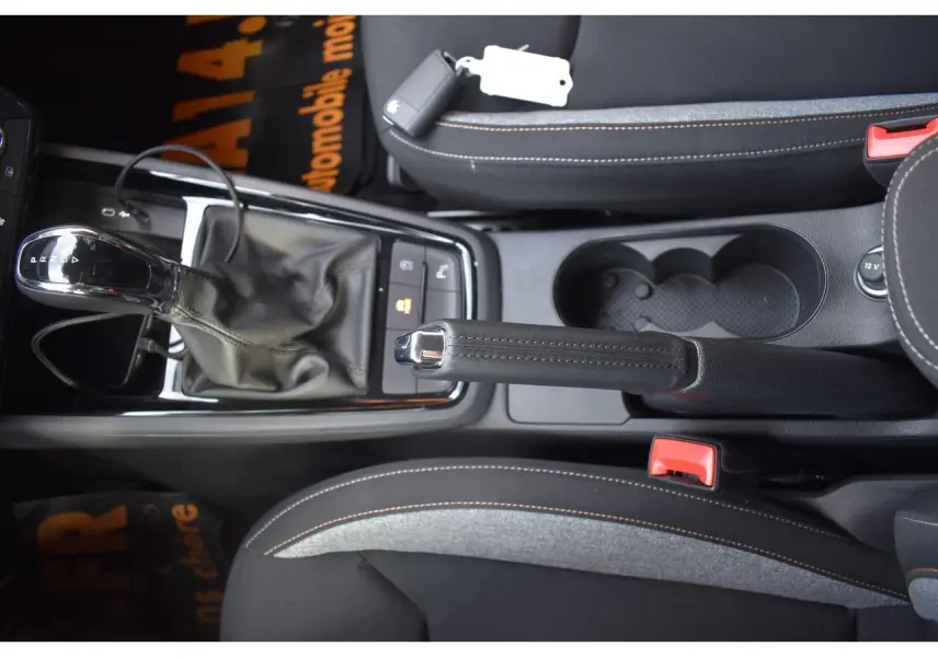 Vue plongeante sur la console centrale noire de la Skoda Scala avec levier de vitesse automatique et frein à main manuel.