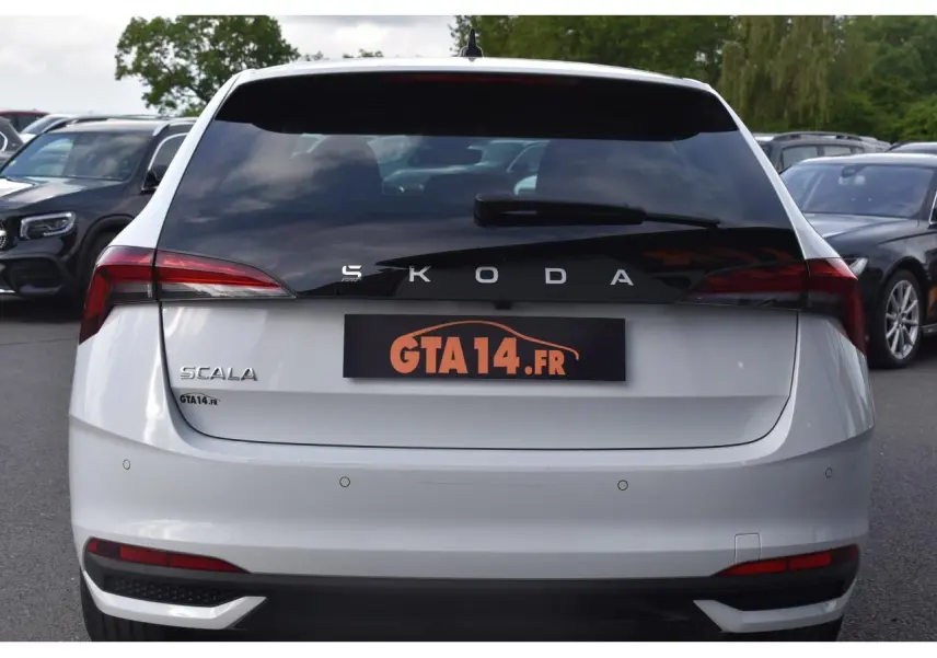 Vue arrière d'une Skoda Scala blanc glacier avec feux arrière Full LED et caméra de recul visible.
