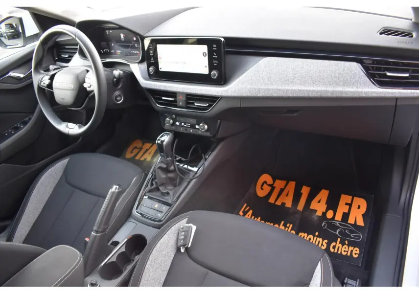 Intérieur de la Skoda Scala blanc glacier vu côté conducteur, avec tableau de bord digital et écran tactile central.