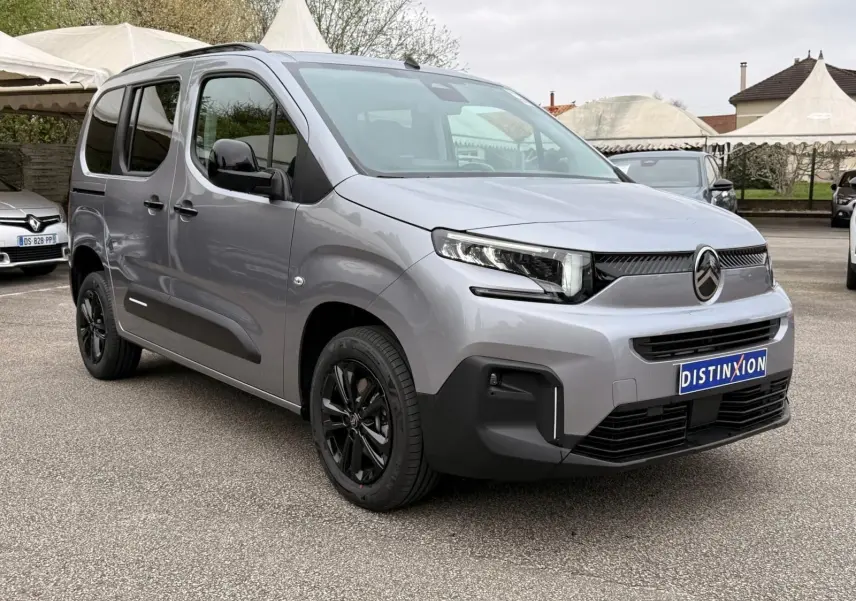 Vue 3/4 avant droit du Citroën Berlingo gris Artense 2025 avec jantes noires et détails noirs contrastants.