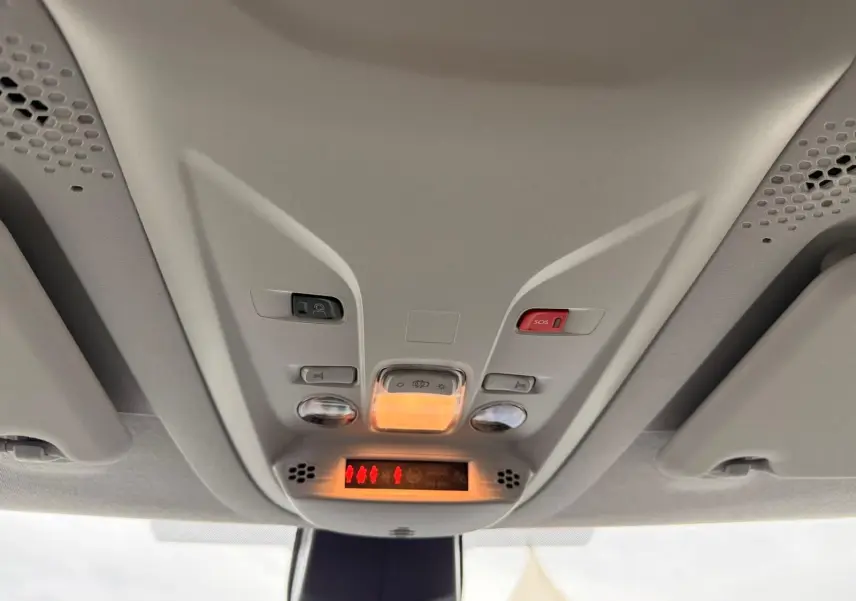Vue intérieure du plafonnier avant du Citroën Berlingo gris, avec commandes d’éclairage et bouton SOS rouge.