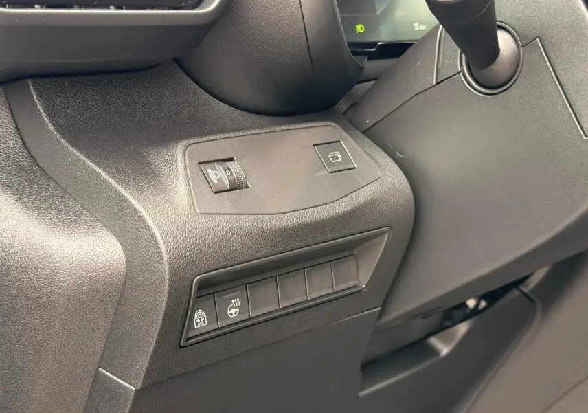 Détail intérieur côté gauche du tableau de bord du Citroën Berlingo gris, avec commandes d’éclairage et chauffage volant.