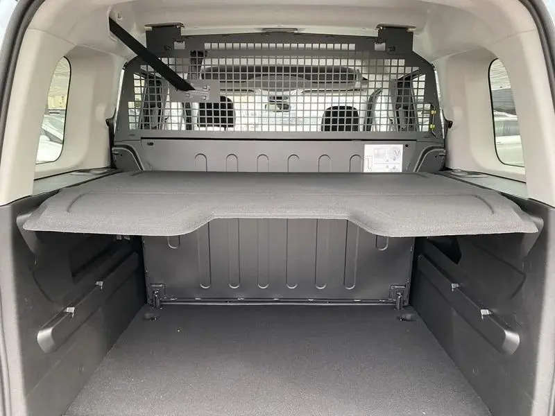 Vue arrière du coffre ouvert du Citroën Berlingo gris Artense 2025 avec sièges arrière rabattus et plancher plat.