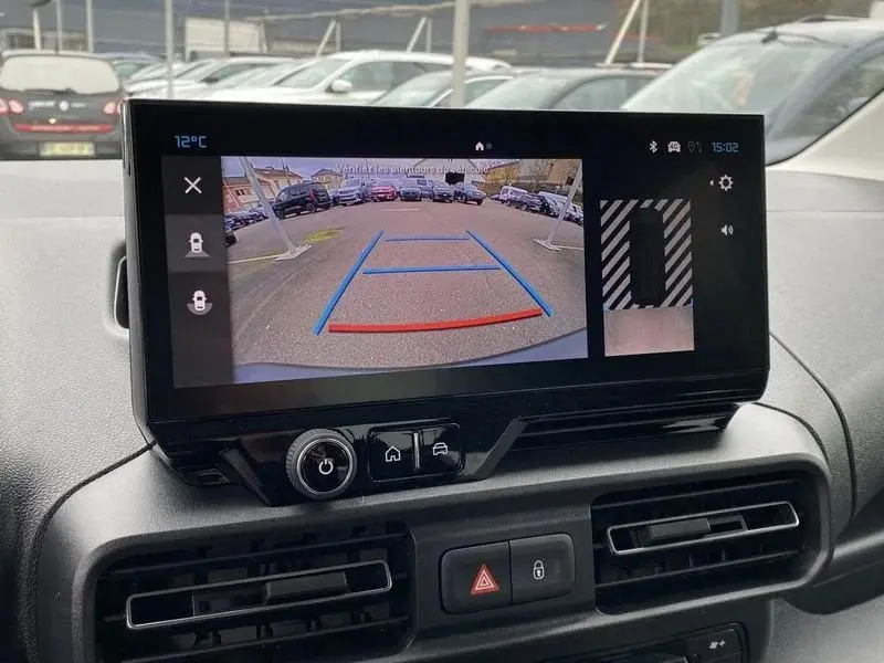 Vue intérieure du coffre d’un Citroën Berlingo gris avec banquette arrière rabattue, montrant l’espace de chargement plat.