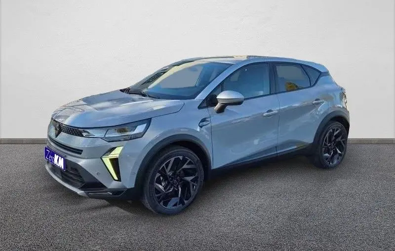 Renault Captur E-Tech hybride gris Rafale, vue 3/4 avant droit avec jantes noires et toit gris.
