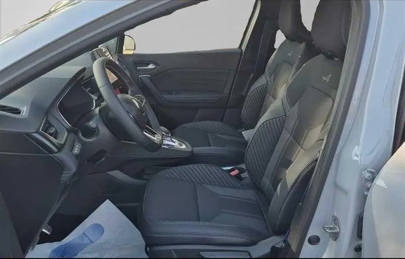 Vue intérieure côté conducteur du Renault Captur E-Tech Hybrid 2025, sièges noirs avec logo Alpine brodé.