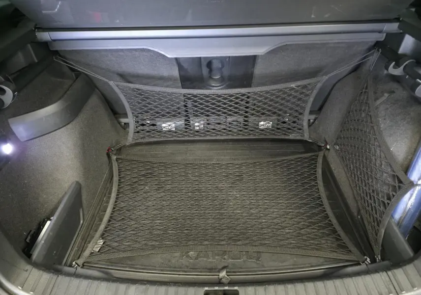 Coffre du Skoda Karoq rouge 2018 vu de dessus, avec filet de rangement et tapis marqué KAROQ.