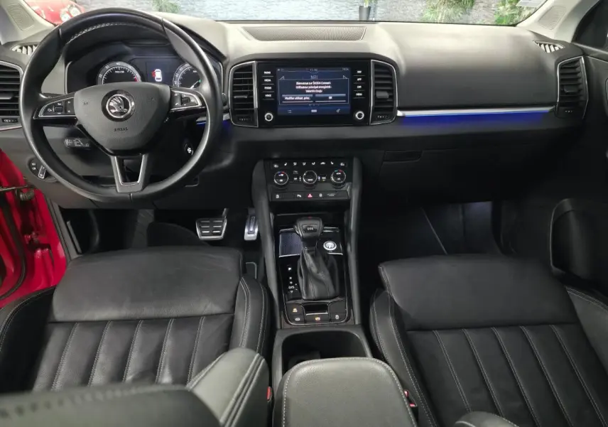 Intérieur noir du Skoda Karoq 2018, vue frontale sur tableau de bord, volant cuir multifonction et console centrale DSG7.